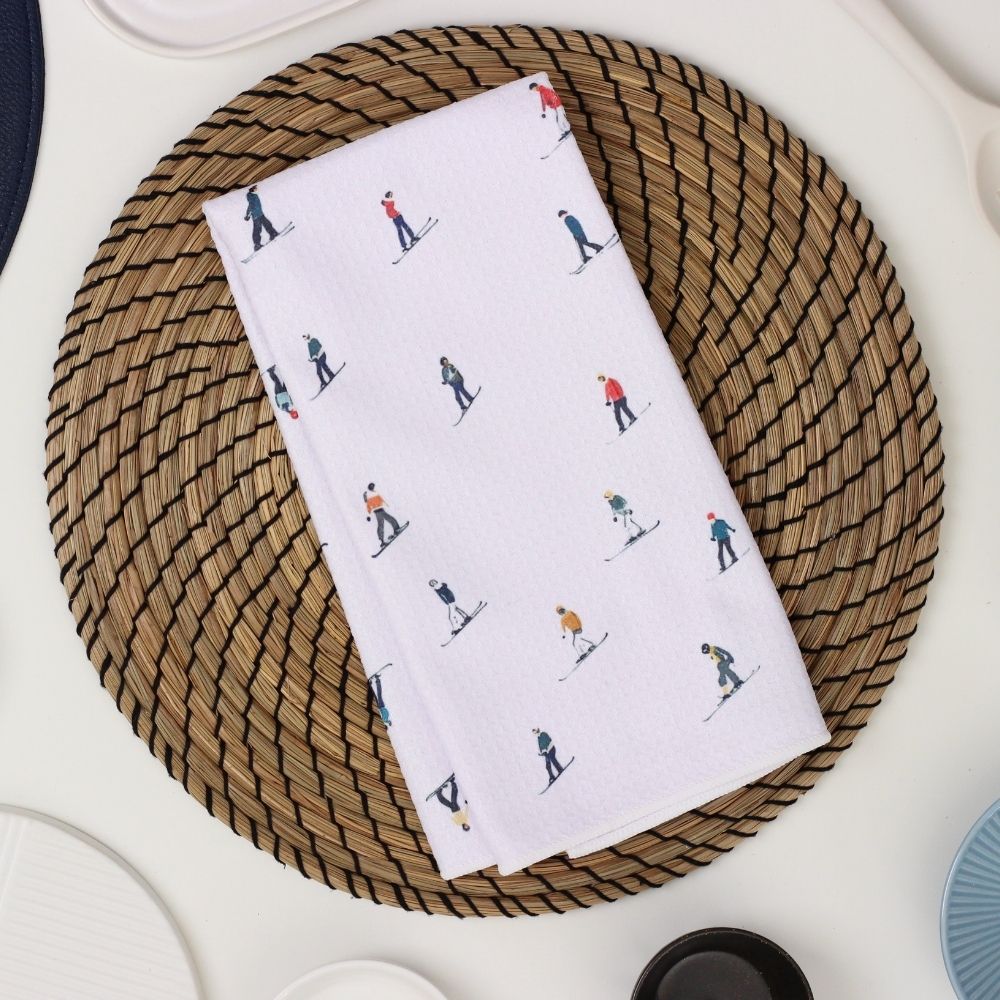 White towel with skiing pattern on a woven placemat